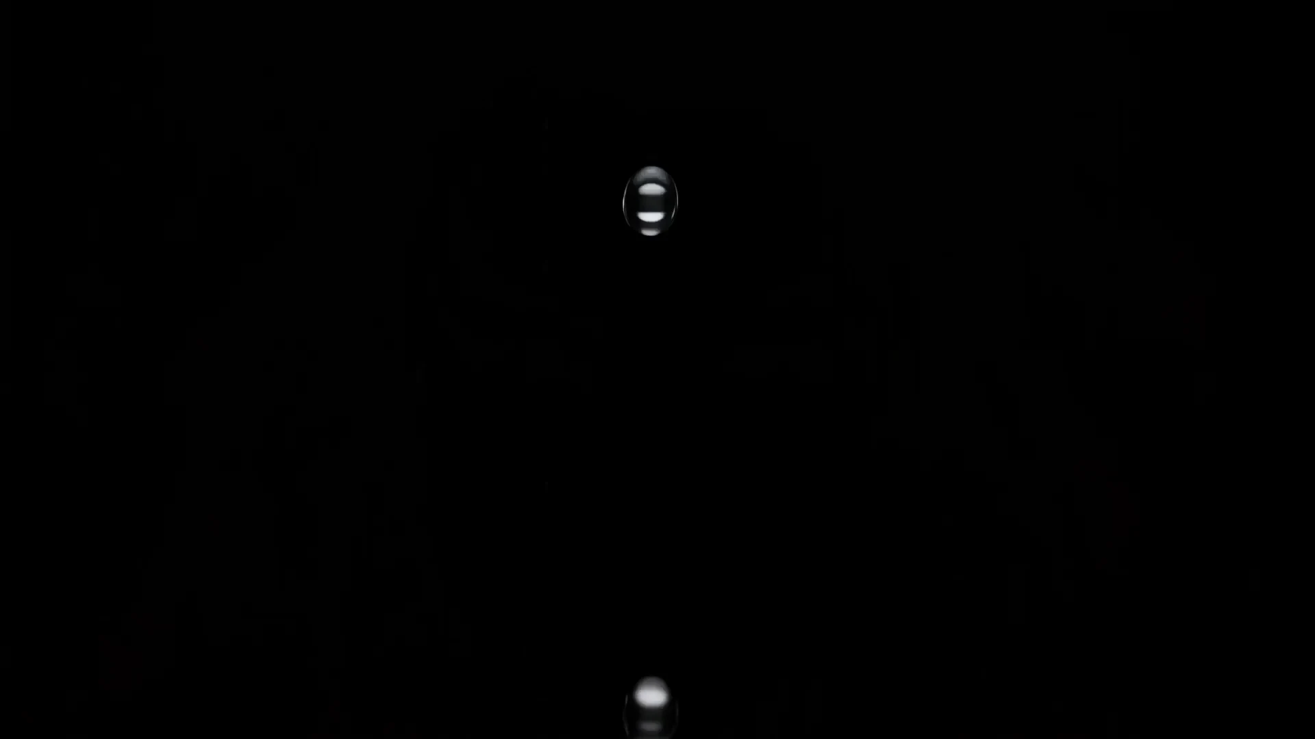 暗闇のなかで一滴が落ち、静かな水面に波紋が広がる